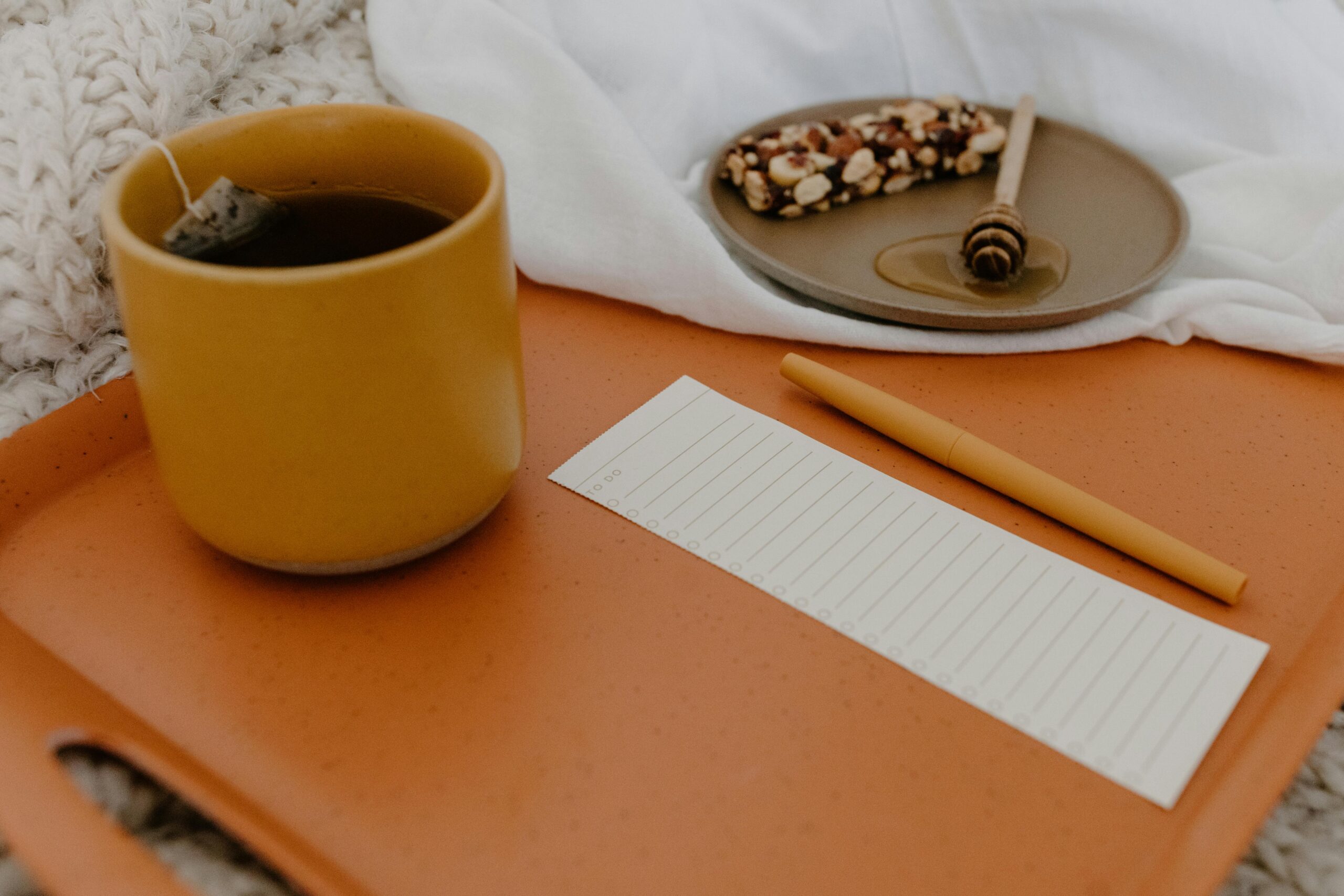 pexels-photo-6690914-6690914 Warm setting with tea, snack bar, and notepad on a tray. Ideal for relaxation concepts.